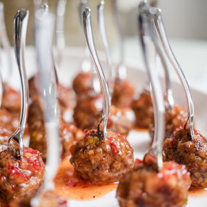 Small meatballs on skewers with a blurred floral background