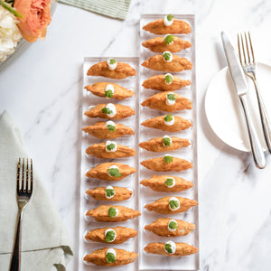 Empanadas on a white plate with flowers and cutlery in the background