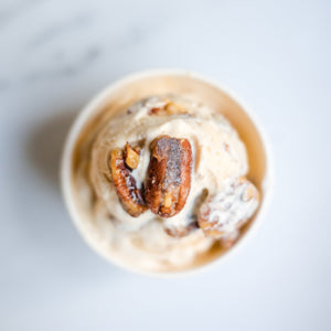 Ice cream with pecans in a cup on a light background