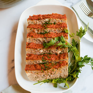 Plated meatloaf with garnish on a white tablecloth