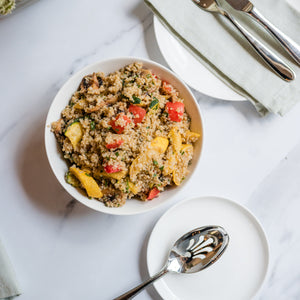  bowl of quinoa salad with vegetables on a marble table